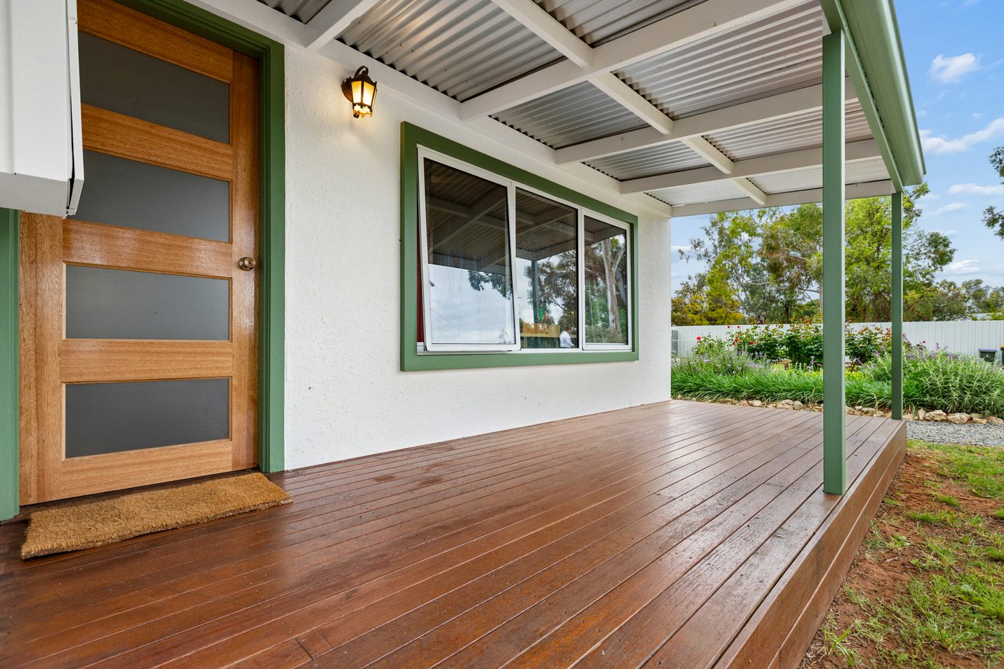 Covered front verandah with timber decking and green trim