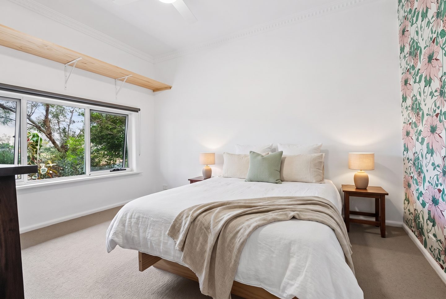 Bedroom with a garden-facing window and floral feature wall