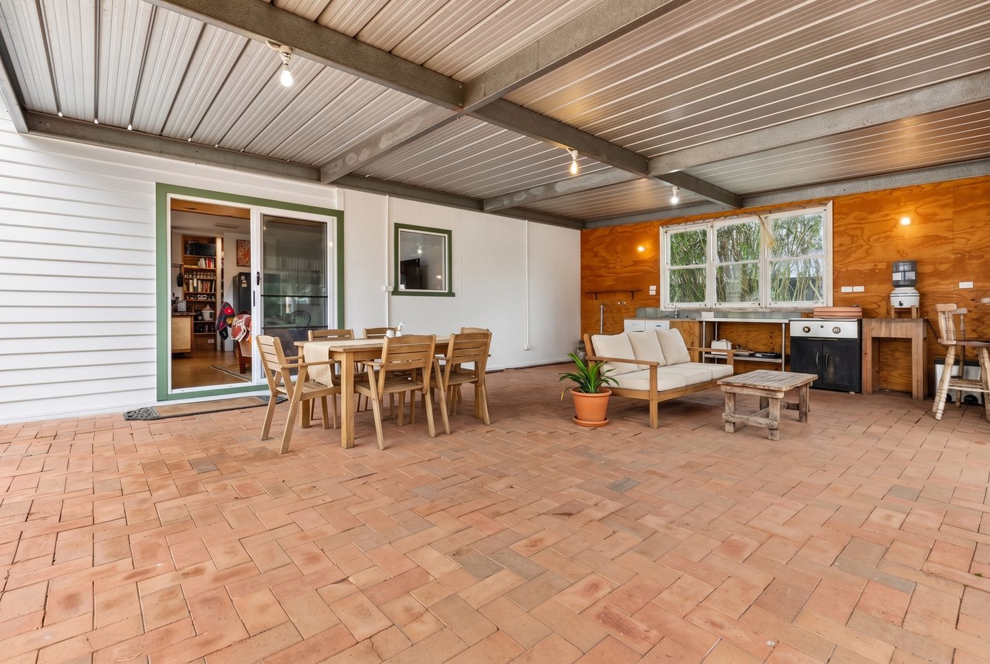 Covered rear patio with brick paving and direct access from the living area