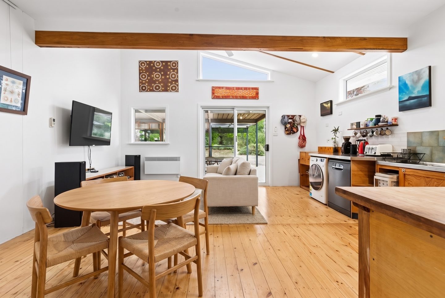 Kitchen and living area with timber floors, high windows and a door to the patio